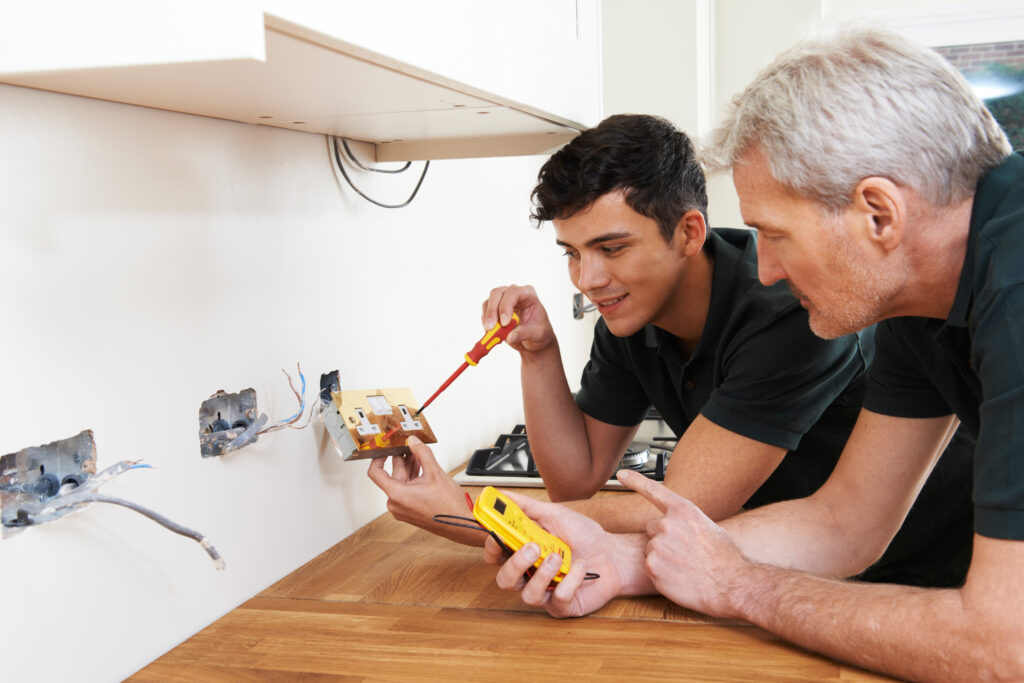 Electrician with apprentice working in a new home