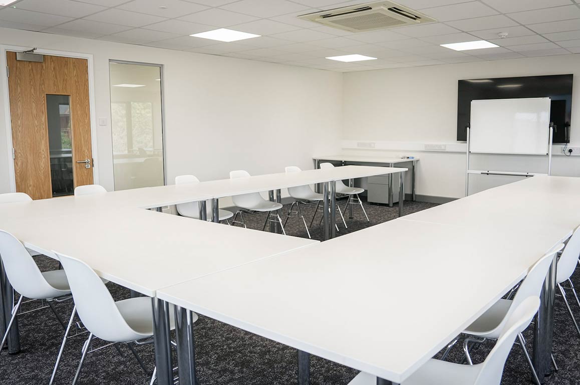 Classroom with whiteboard and tables at PASS Stevenage